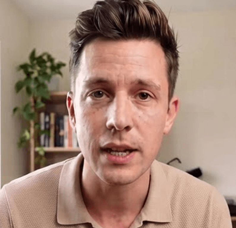 A professional speaking in front of a bookshelf