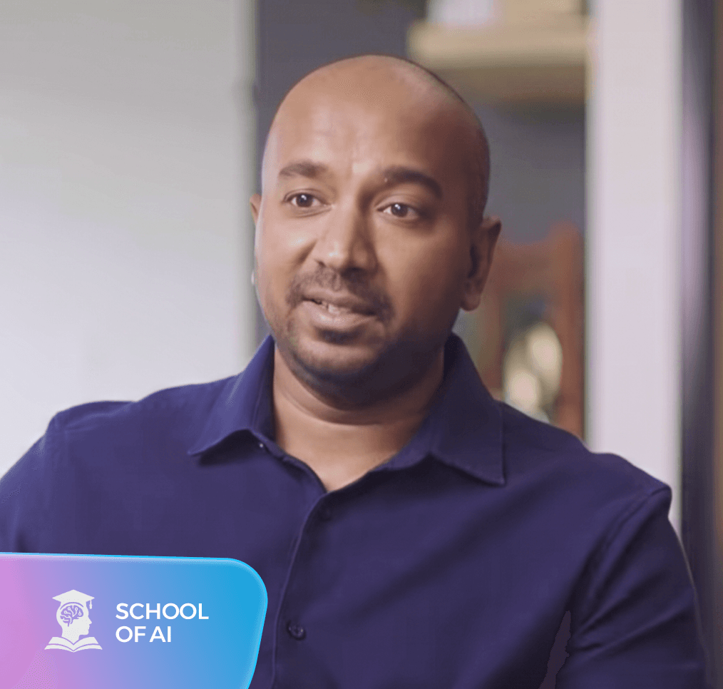 رجل حليق الرأس وملتح يرتدي قميصاً أزرق داكناً. يظهر شعار "SCHOOL OF AI" في الزاوية السفلية اليسرى.