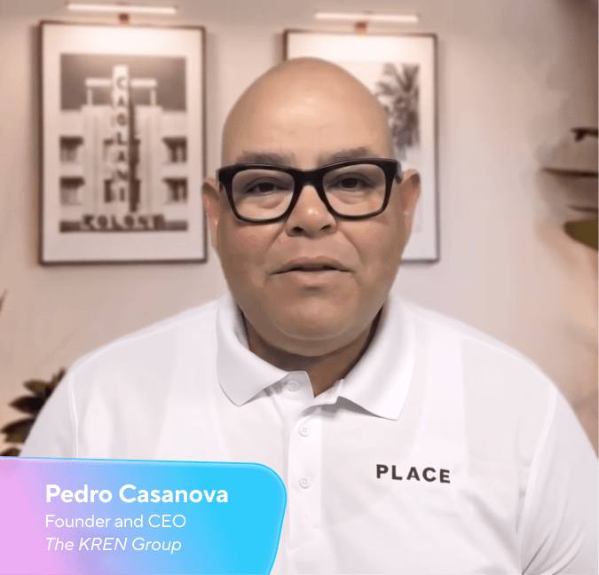 Pedro Casanova, Founder and CEO of The KREN Group, a bald man wearing glasses and a white polo shirt with "PLACE" written on it.