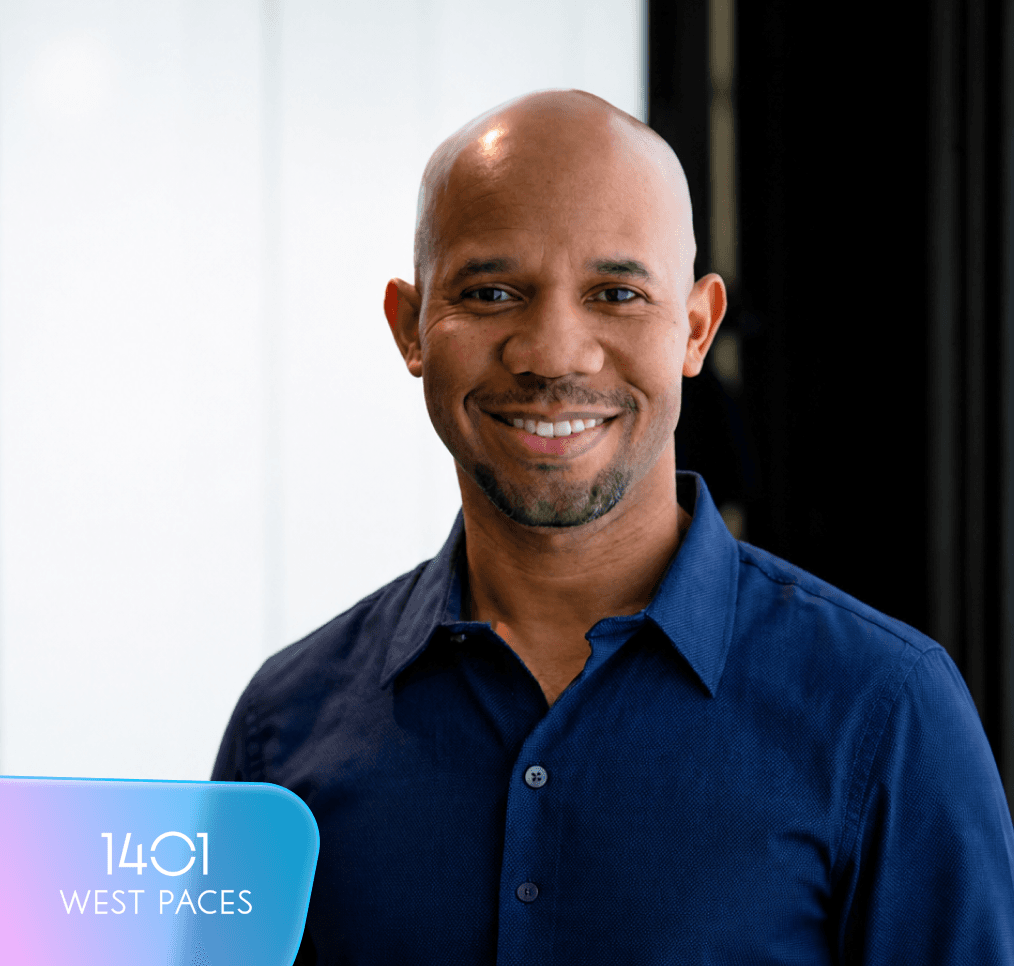 Smiling bald man in a blue shirt. Text overlay reads "1401 WEST PACES."