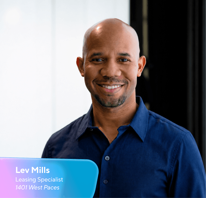 Smiling bald Black man in a blue shirt, with an overlay displaying "Lev Mills, Leasing Specialist, 1401 West Paces."