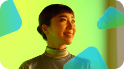 Smiling woman looking up against a vibrant yellow-green background with abstract shapes.